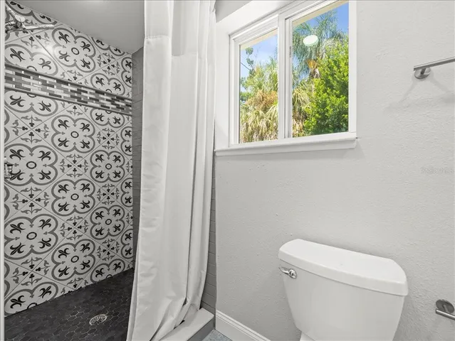 a white toilet sitting next to a window