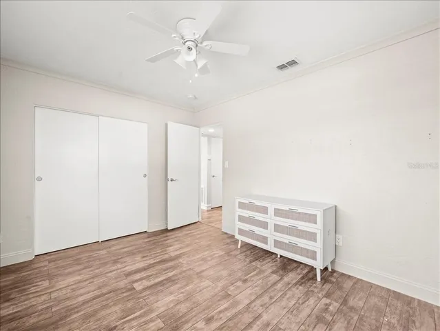 a view of room with wooden floor and ceiling fan