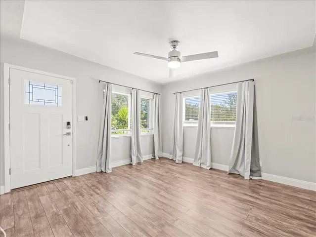 a view of a livingroom with wooden floor and a ceiling fan