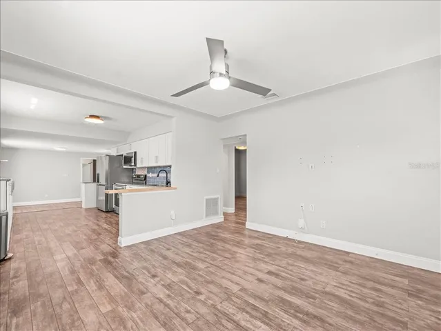 a view of a kitchen with wooden floor and a sink