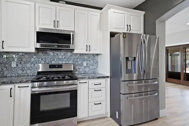 a kitchen with appliances a refrigerator and a stove top oven