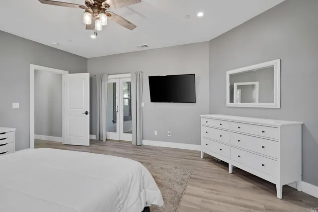 a bedroom with a bed and a flat tv screen on dresser