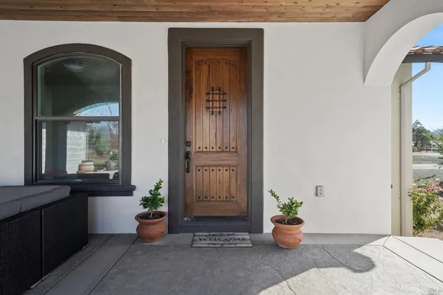 a view of a entryway door of the house with outdoor seating