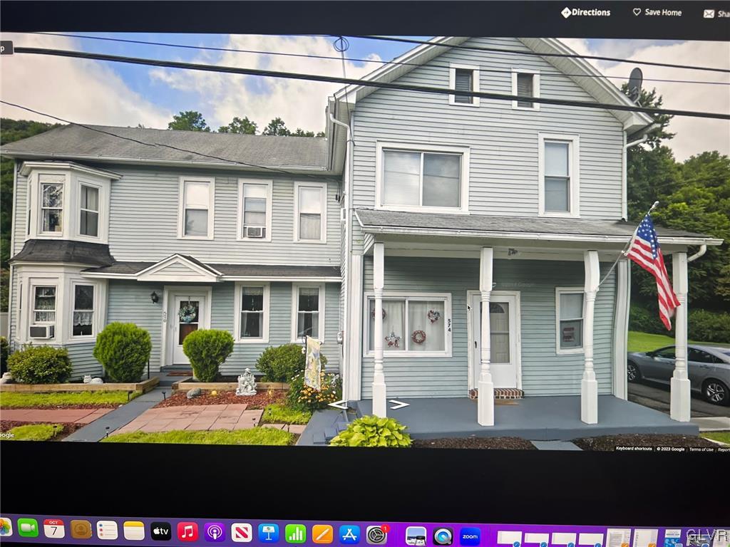 a view of a brick house with large windows and a yard