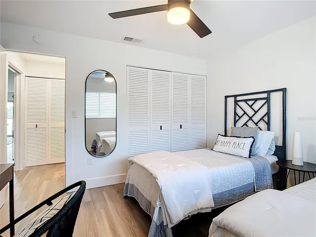 a bedroom with two beds and a desk