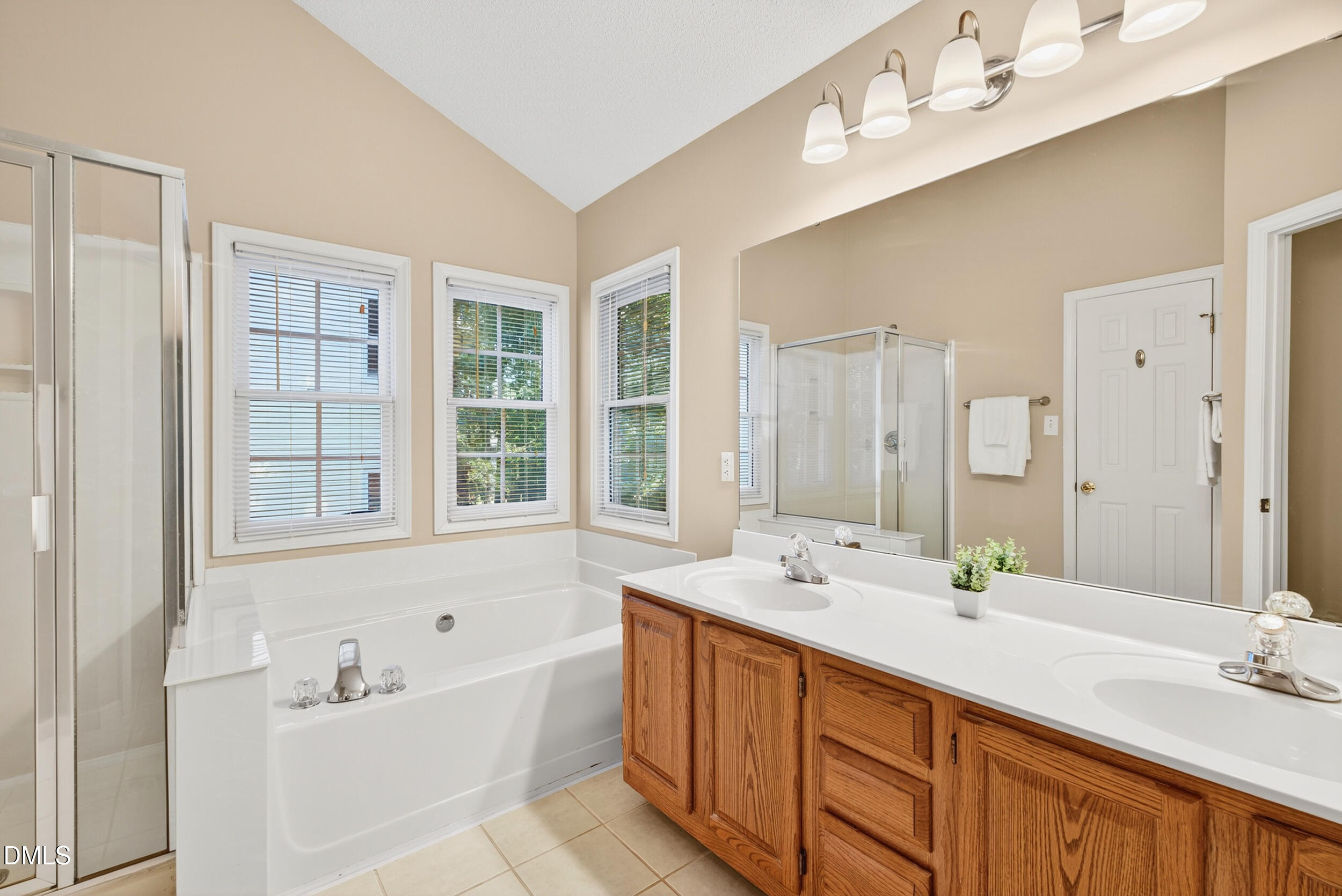 105 Point Harbor Drive Cary, NC 27519 - Photo 24 of 39 a bathroom with a double vanity sink large mirror and a bathtub