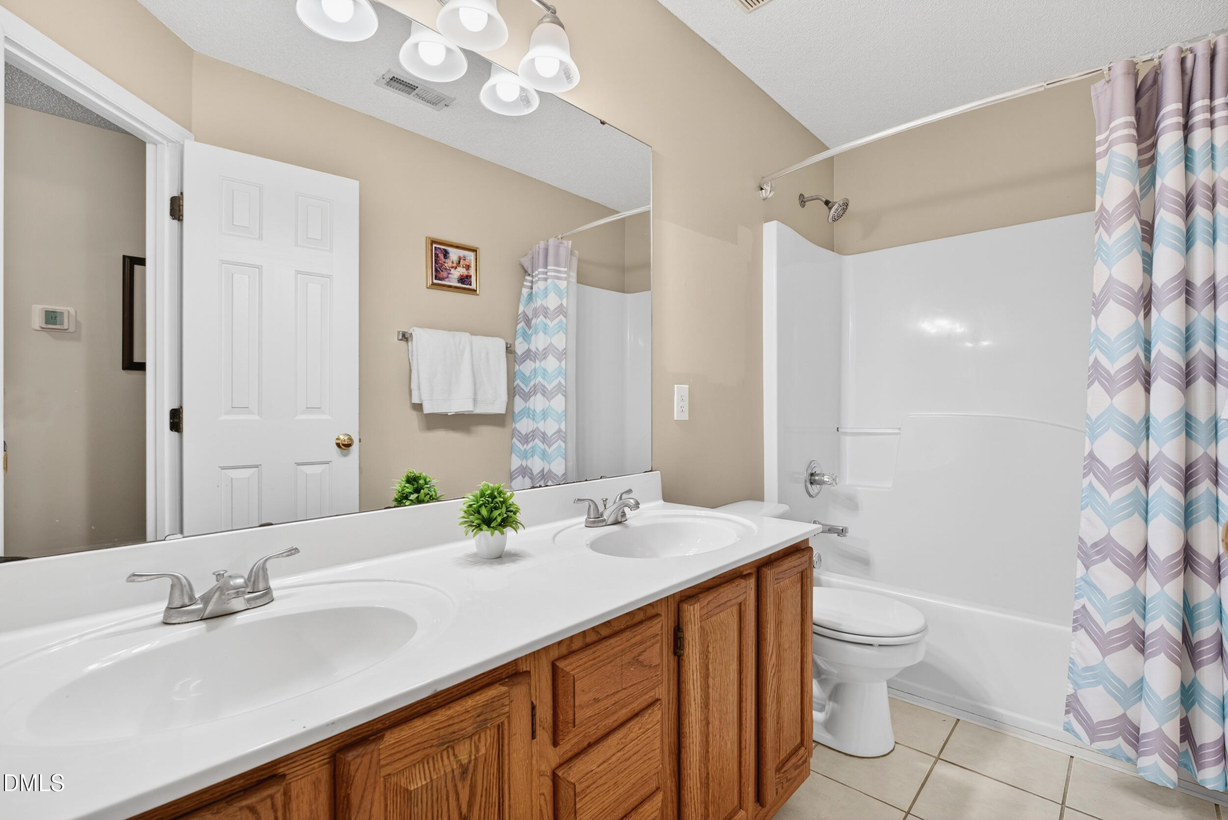 105 Point Harbor Drive Cary, NC 27519 - Photo 31 of 39 a bathroom with a granite countertop sink toilet a large mirror a shower and a bathtub