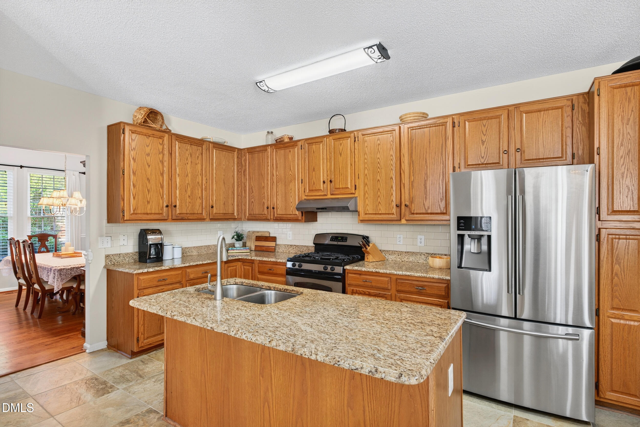 105 Point Harbor Drive Cary, NC 27519 - Photo 6 of 39 a kitchen with granite countertop a refrigerator a stove and white cabinets