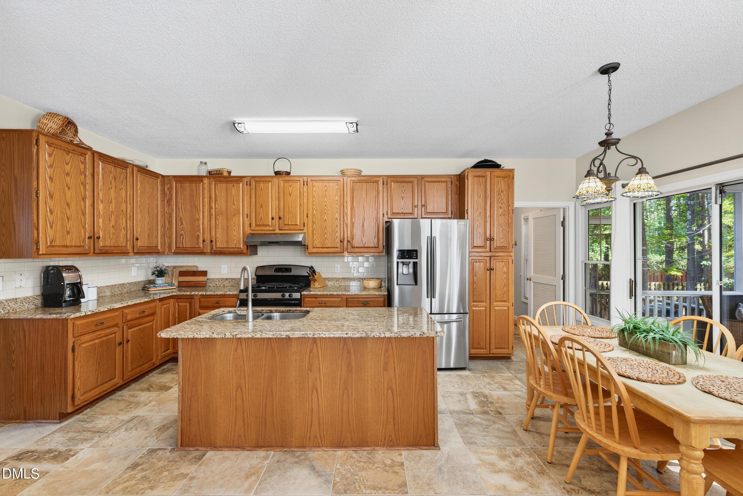 105 Point Harbor Drive Cary, NC 27519 - Photo 8 of 39 a kitchen with stainless steel appliances granite countertop a stove top oven a sink dishwasher a dining table and chairs with wooden floor