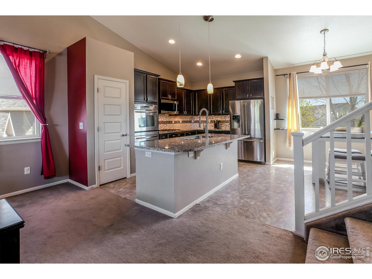 8594 Raspberry Drive Frederick, CO 80504 - Photo 11 of 40 a kitchen view with stainless steel appliances kitchen island granite countertop a refrigerator and a stove top oven