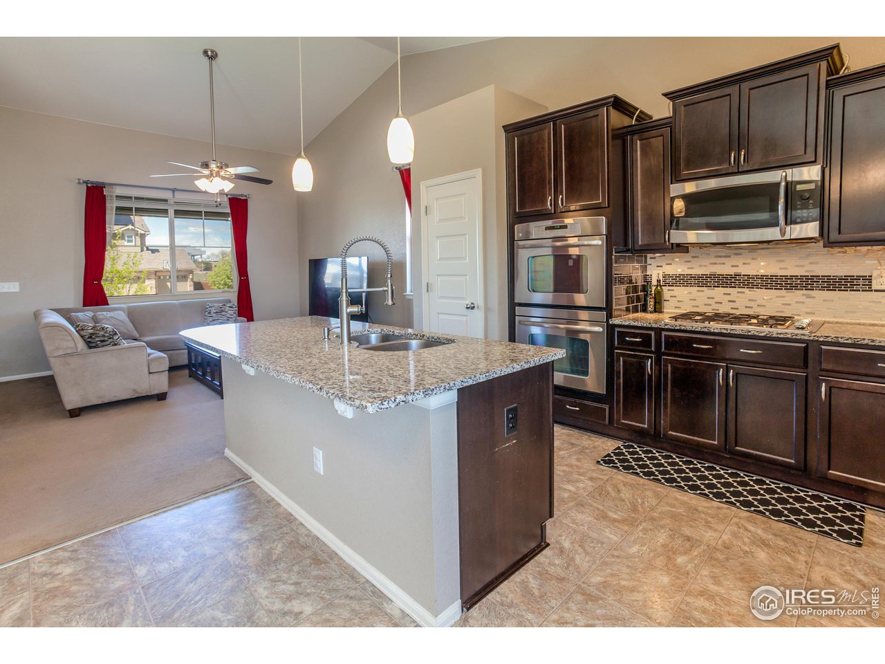 8594 Raspberry Drive Frederick, CO 80504 - Photo 12 of 40 a large kitchen with kitchen island granite countertop a stove refrigerator and a sink