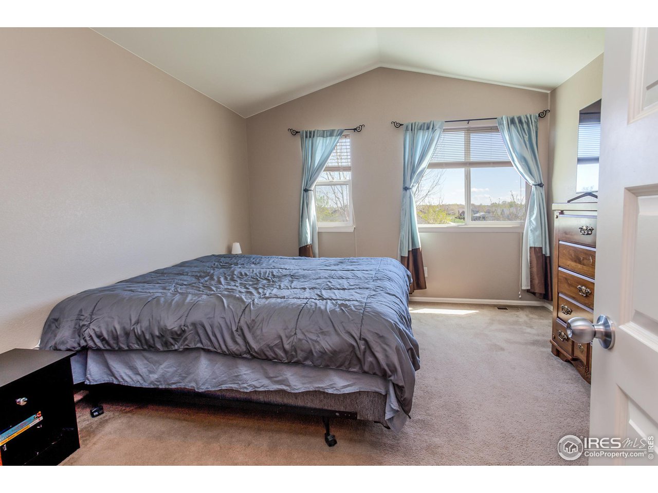 8594 Raspberry Drive Frederick, CO 80504 - Photo 24 of 40 a bedroom with a bed a dresser and next to a window