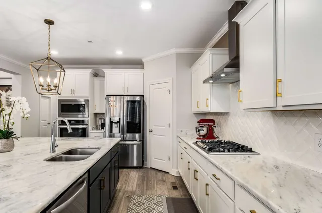 a living room with furniture a flat screen tv and kitchen view