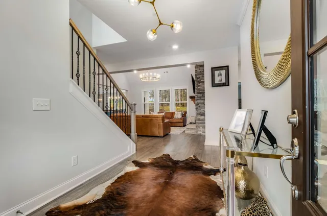 a dining room with furniture a chandelier and wooden floor