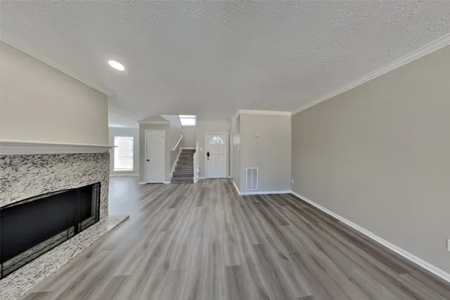 a view of empty room with wooden floor and fireplace