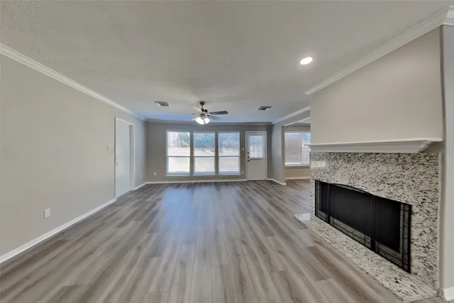 an empty room with windows and fireplace