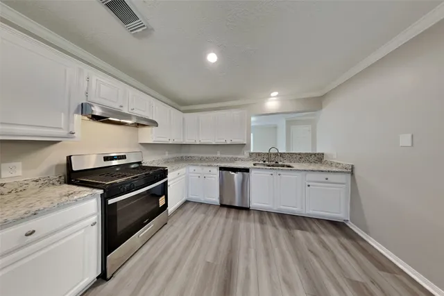 a kitchen with granite countertop stainless steel appliances and wooden cabinets