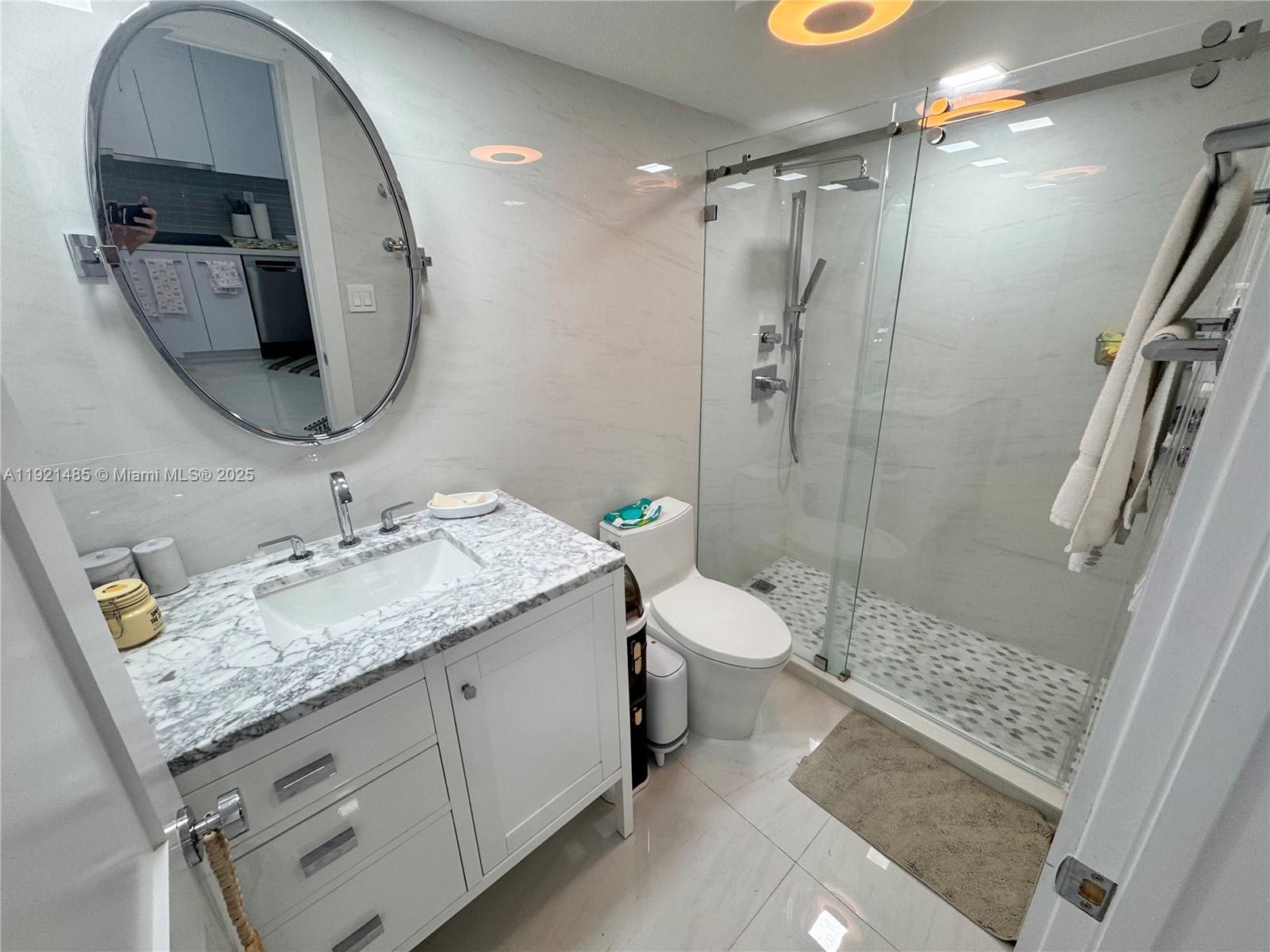 2899 Collins Avenue, Unit 915 Miami Beach, FL 33140 - Photo 9 of 31 a bathroom with a granite countertop sink toilet and shower