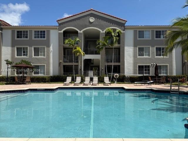6831 Southwest 44th Street, Unit 203 Miami, FL 33155 - Photo 2 of 15 a front view of a house with swimming pool having outdoor seating