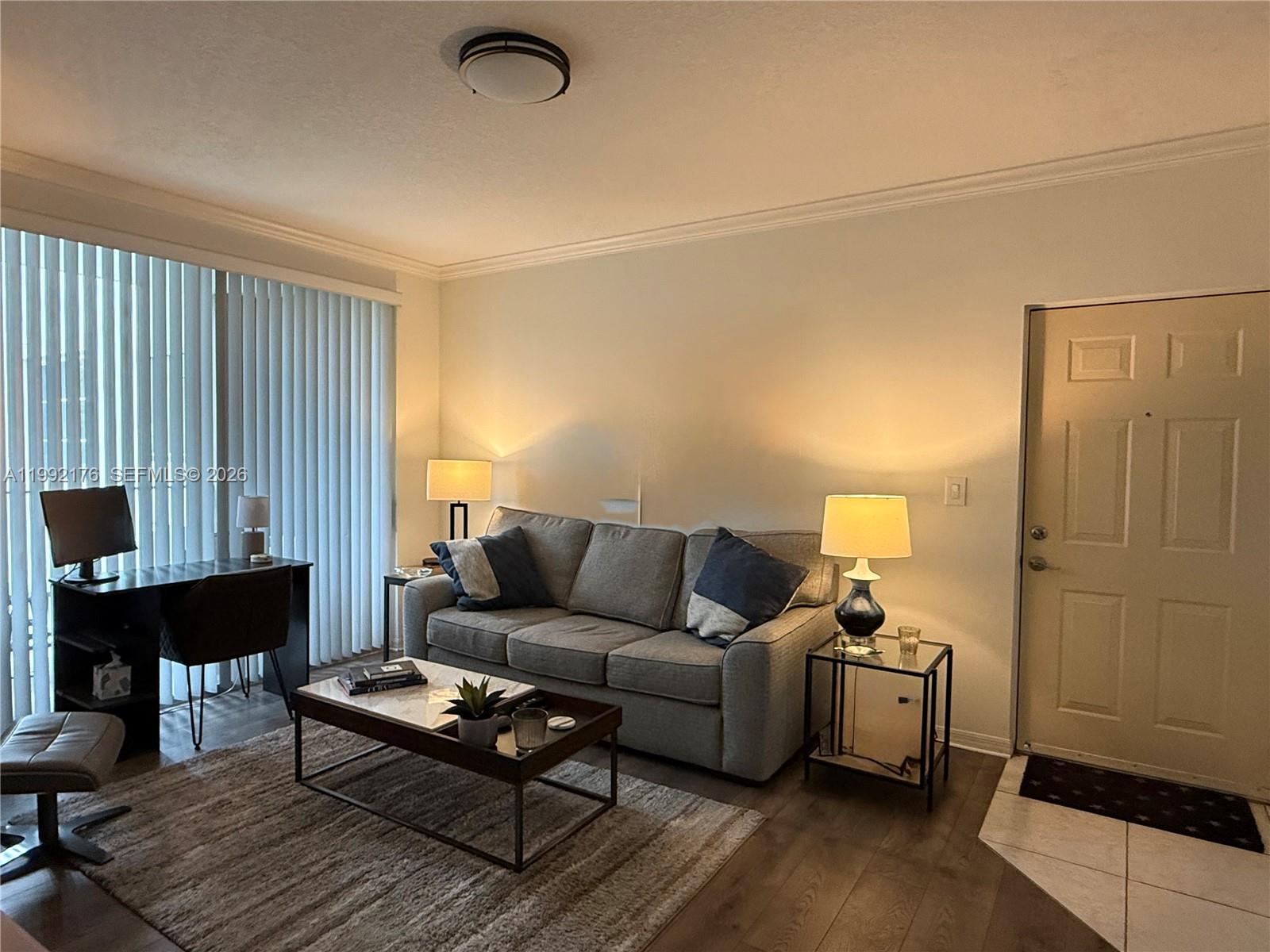 6831 Southwest 44th Street, Unit 203 Miami, FL 33155 - Photo 5 of 15 a living room with furniture a table and a window