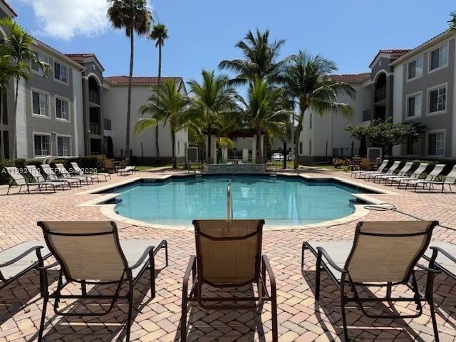 6831 Southwest 44th Street, Unit 203 Miami, FL 33155 - Photo 8 of 15 a swimming pool with outdoor seating and yard