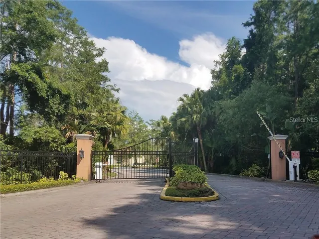 a view of a tennis ground with large trees