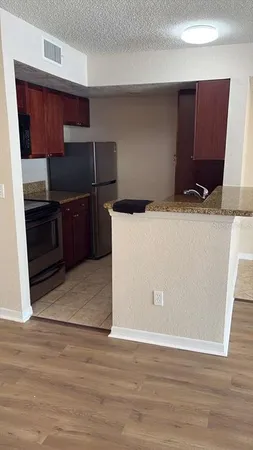 a view of an empty room with wooden floor and windows