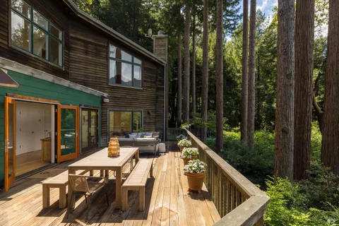 a view of a patio with table and chairs with wooden floor and fence