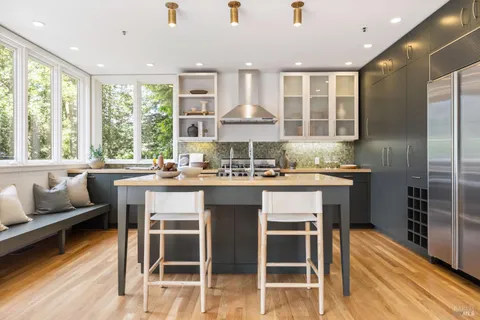 a kitchen with a table chairs refrigerator and cabinets