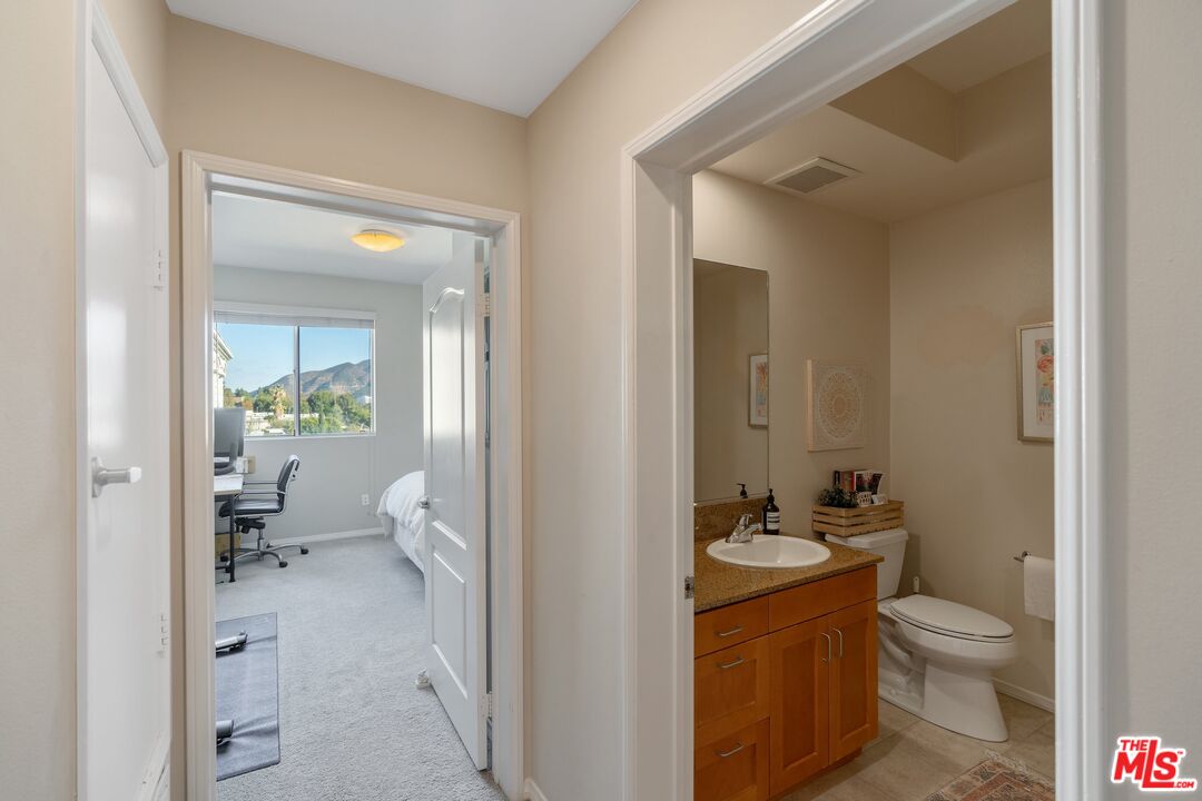 4170 Fair Avenue, Unit PH2 Studio City, CA 91602 - Photo 21 of 42 a bathroom with a granite countertop toilet a sink and a mirror
