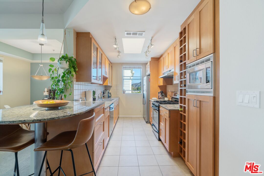 4170 Fair Avenue, Unit PH2 Studio City, CA 91602 - Photo 8 of 42 a kitchen with stainless steel appliances granite countertop a kitchen island a stove and a refrigerator