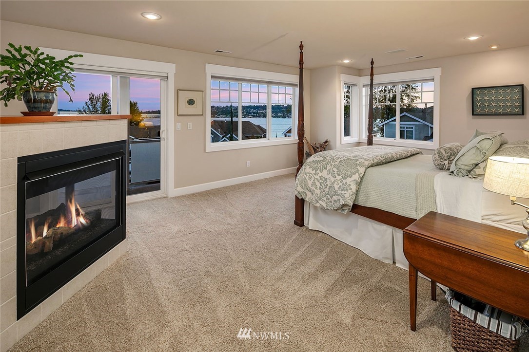 2716 Williams Avenue North Renton, WA 98056 - Photo 22 of 38 a spacious bedroom with a bed a fireplace and potted plant with wooden floor