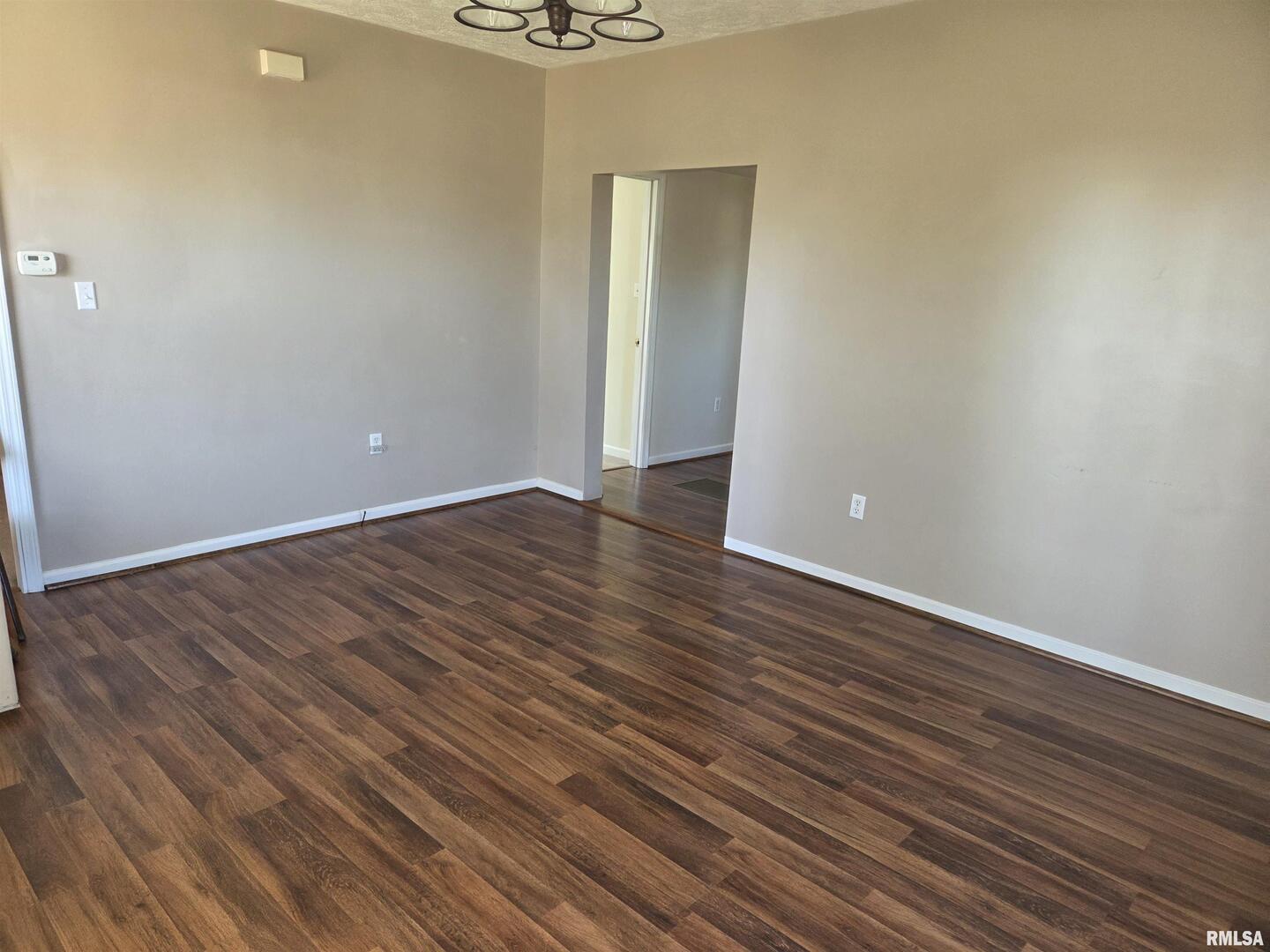 208 West Cherry Street Springerton, IL 62887 - Photo 7 of 13 a view of an empty room with wooden floor and a window