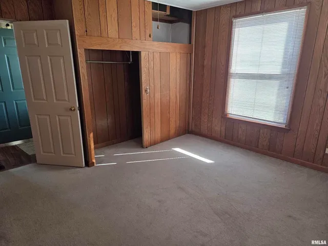 an empty room with a ceiling fan and a window