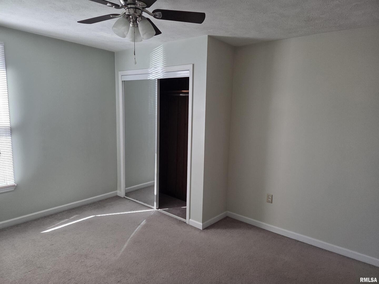 208 West Cherry Street Springerton, IL 62887 - Photo 9 of 13 an empty room with a ceiling fan and a window