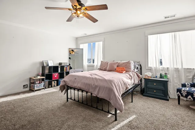 a spacious bedroom with a bed and a chandelier