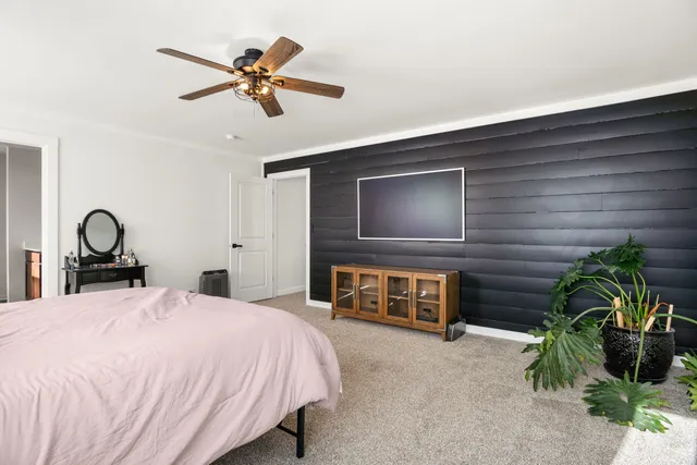 a bedroom with a bed and a ceiling fan