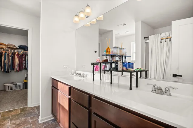 a dining hall with granite countertop a sink a mirror and chandelier