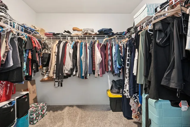 a view of walk in closet with clothes and shoes