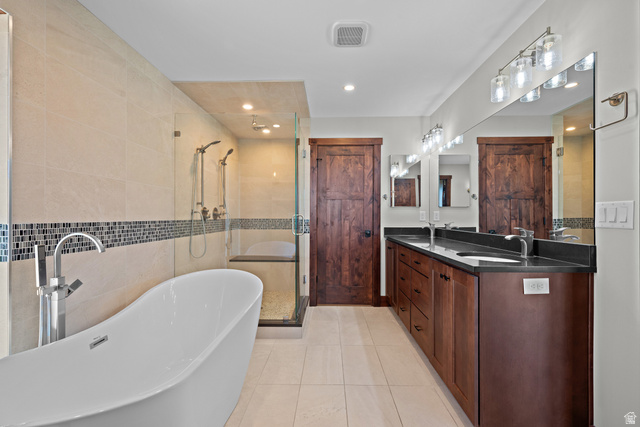 4221 Juniper Circle Alpine, UT 84004 - Photo 14 of 66 Modern bathroom featuring a freestanding soaking tub, glass-enclosed shower with dual showerheads, and light-toned floor tiling
