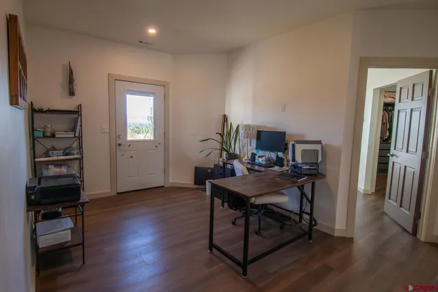 a view of a workspace with furniture and wooden floor