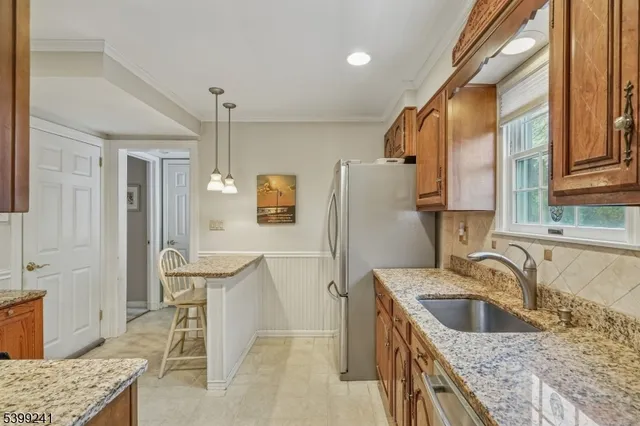 a kitchen with a sink refrigerator and cabinets