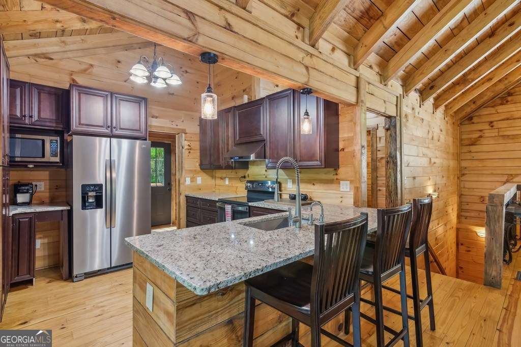245 Timberwalk Drive, Unit 16 Ellijay, GA 30540 - Photo 14 of 56 a kitchen with stainless steel appliances granite countertop a table chairs and a refrigerator