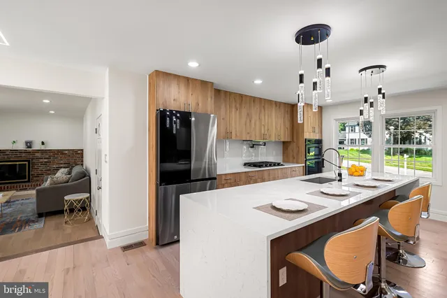 a kitchen that has a kitchen island wooden cabinets and refrigerator