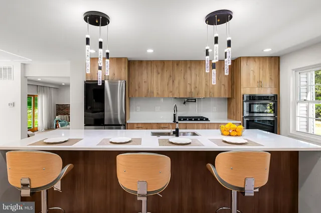 a kitchen with a dining table chairs and chandelier