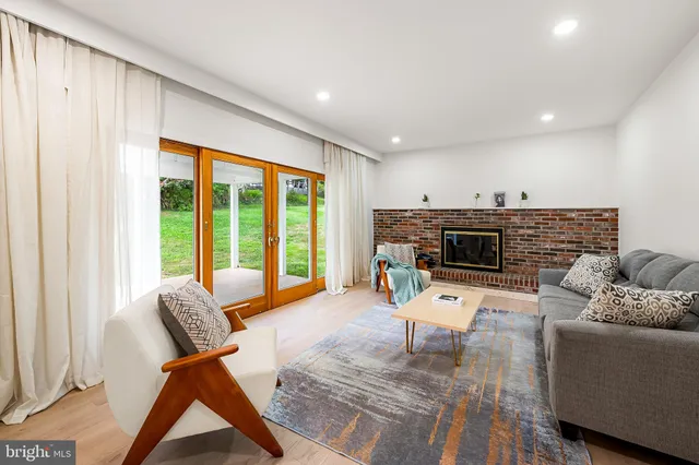 a living room with furniture a fireplace and a floor to ceiling window