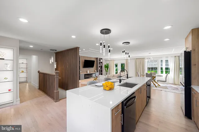 a kitchen with stainless steel appliances a sink a stove a refrigerator cabinets and living room view