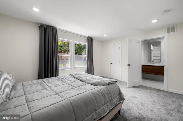 a spacious bedroom with a bed and a window