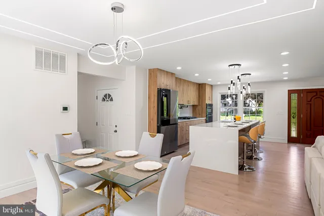 a dining room with wooden floor a chandelier a wooden table and chairs