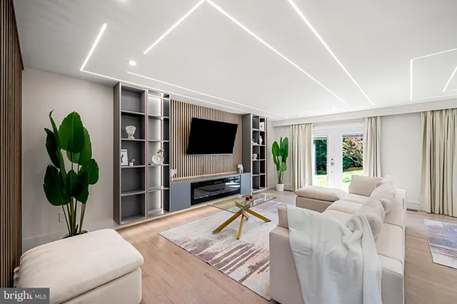 a living room with furniture a flat screen tv and a large window